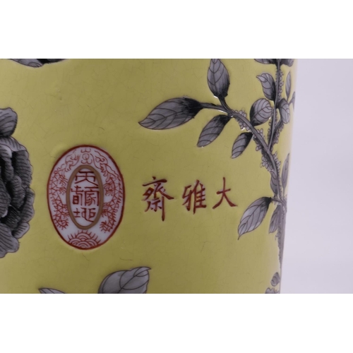 18 - A Chinese yellow ground porcelain cylinder vase with black and white decoration of Asiatic flowers, ... 