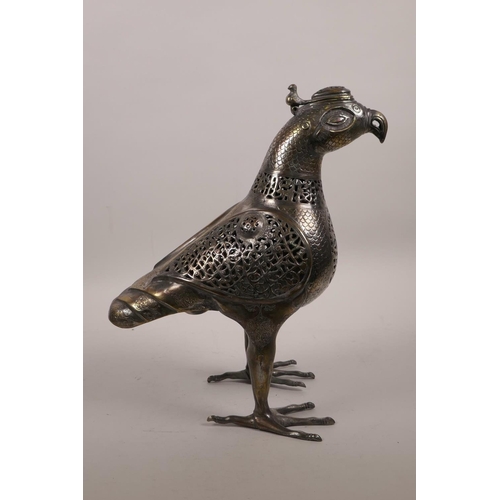 49 - An Islamic silvered metal censer in the form of a bird with pierced scrolling decoration, 12