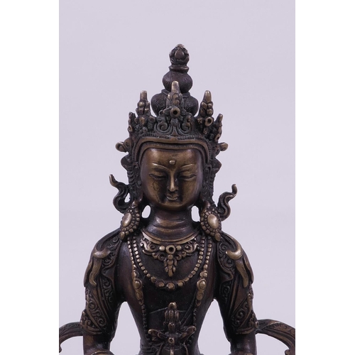 53 - A Sino-Tibetan bronze of Buddha seated on a lotus throne holding a stupa, 8½