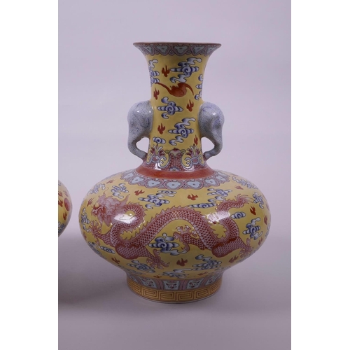 58 - A pair of Chinese yellow ground vases with two elephant head handles and iron red dragon decoration,... 