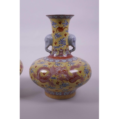 58 - A pair of Chinese yellow ground vases with two elephant head handles and iron red dragon decoration,... 