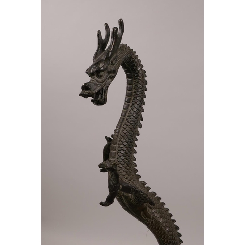 61 - An Oriental bronze figure of a rearing dragon, 16½