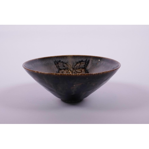 65 - A Chinese Cizhou kiln pottery bowl of conical form with butterfly decoration, 6½