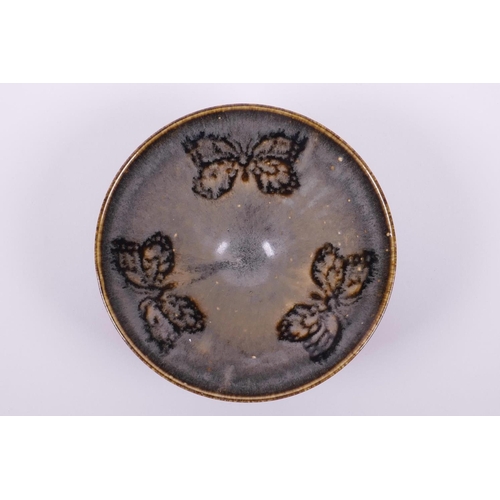 65 - A Chinese Cizhou kiln pottery bowl of conical form with butterfly decoration, 6½