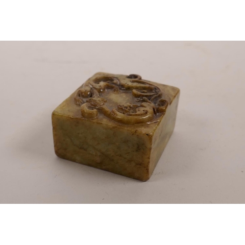 67 - A Chinese hardstone square form seal with carved dragon decoration to top, 2