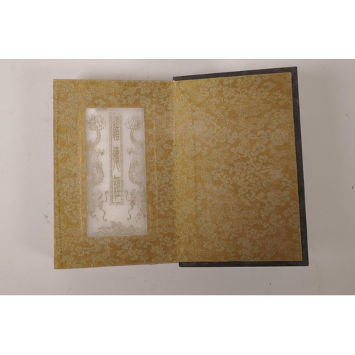 115 - A Chinese wood and silk bound book containing gilt engraved white jade tablets, 6