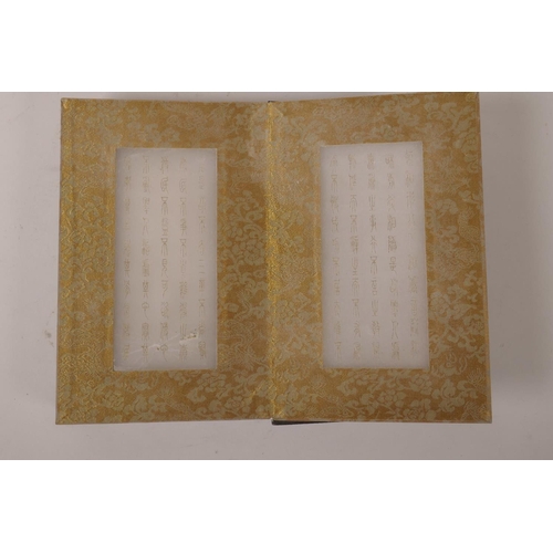 115 - A Chinese wood and silk bound book containing gilt engraved white jade tablets, 6