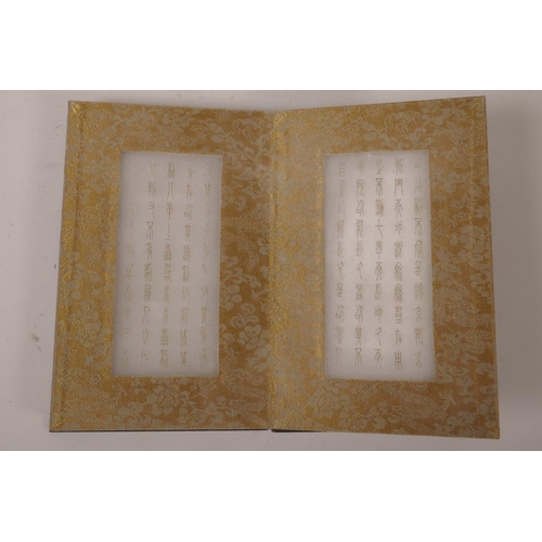 115 - A Chinese wood and silk bound book containing gilt engraved white jade tablets, 6