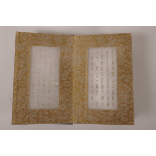 115 - A Chinese wood and silk bound book containing gilt engraved white jade tablets, 6