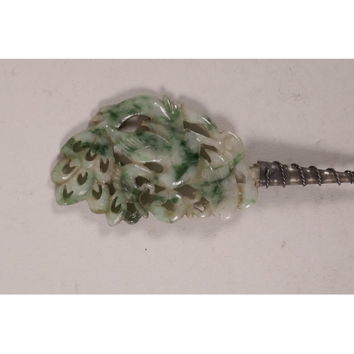 27 - A Chinese silvered metal hairpin, the marbled green jade handle with carved and pierced phoenix deco... 