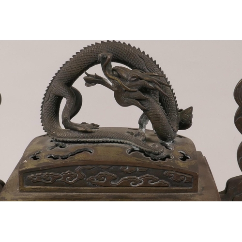 76 - A Chinese bronze censer, the pierced cover with cast dragon handle, the body with flare handles and ... 