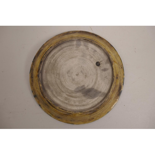 15 - A Chinese pottery saucer in the Sancai palette with incised floral decoration, 6