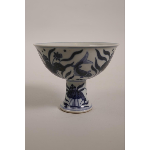 43 - A Chinese blue and white porcelain stem cup decorated with carp in a lotus pond, 6 character mark to... 