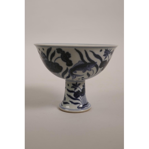 43 - A Chinese blue and white porcelain stem cup decorated with carp in a lotus pond, 6 character mark to... 