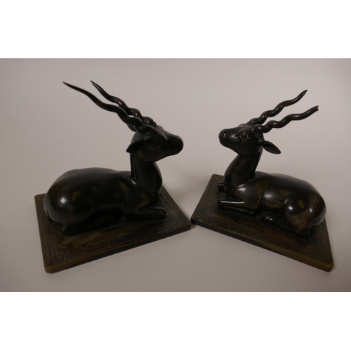 50 - A pair of horn figures of recumbent antelope, on horn bases, 4½