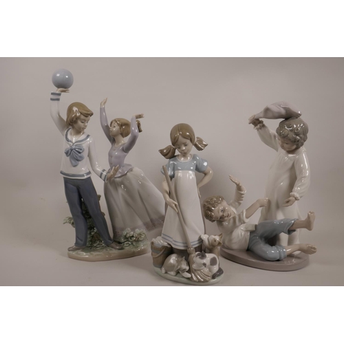 57 - A Lladro figurine of a boy and girl playing with a ball, 11