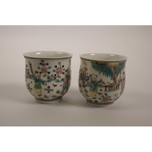 60 - A pair of Chinese polychrome enamelled porcelain tea bowls decorated with boys playing in a garden, ... 