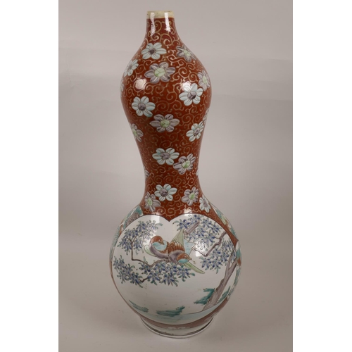 9 - A Chinese gourd shaped vase decorated with panels of exotic birds and flowers on a swirled red groun... 