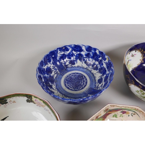 10 - An Oriental blue and white porcelain bowl decorated with flowering trees on a pedestal base, 9¾