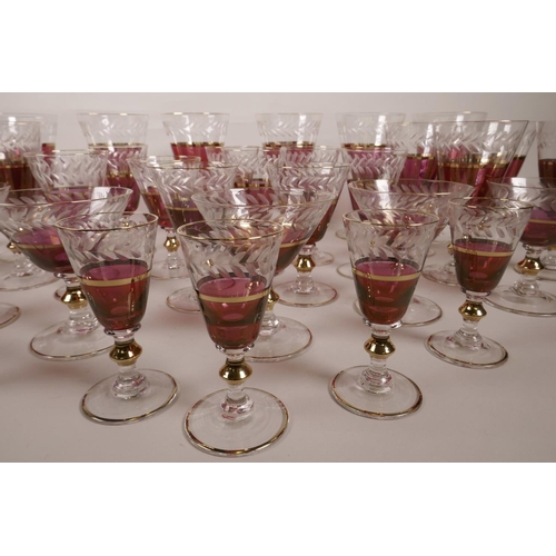 42 - A suite of thirty five fine cranberry drinking glasses on clear glass stems, with cut leaf decoratio... 