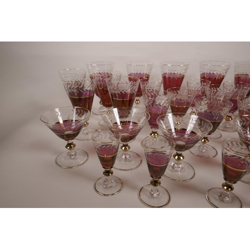 42 - A suite of thirty five fine cranberry drinking glasses on clear glass stems, with cut leaf decoratio... 