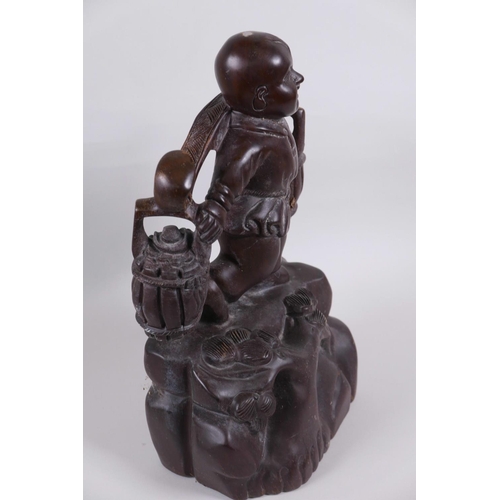 48 - An Oriental carved wood figurine of a boy carrying two baskets on a yoke, 12