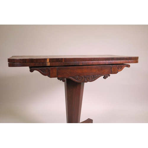 1180 - A Regency rosewood fold over card table on tapered octagonal column and quadraform base on scroll ca... 