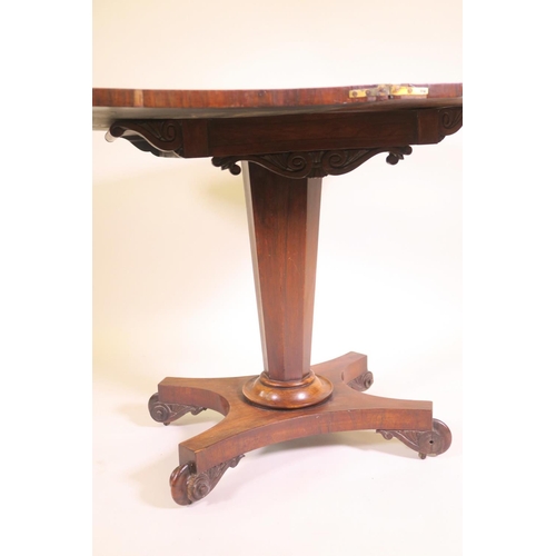 1180 - A Regency rosewood fold over card table on tapered octagonal column and quadraform base on scroll ca... 