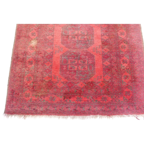 1194 - A Persian red ground rug with geometric designs, 70