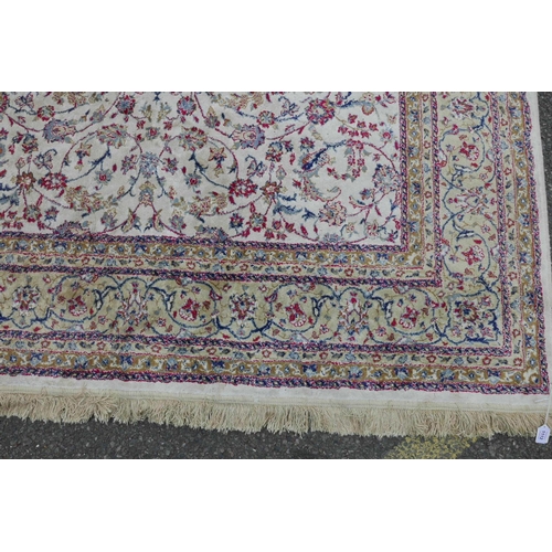 1205 - A Kashmiri ivory ground carpet with all over floral design and cream borders, 116