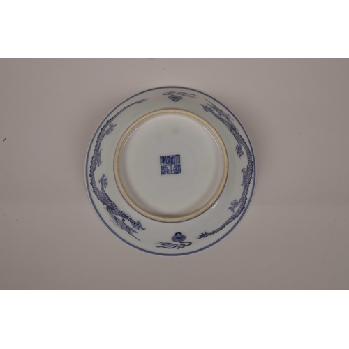 20 - A Chinese blue and white porcelain dish decorated with a dragon chasing the flaming pearl, seal mark... 