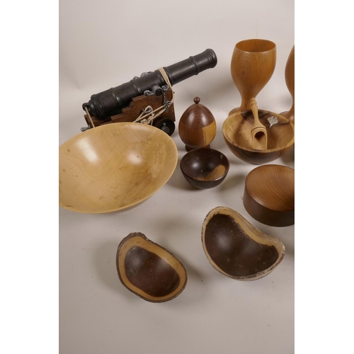 57 - A collection of treen bowls, dishes and jars, and a table cannon