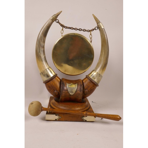 17 - A C19th table top dinner gong, the brass gong supported by a pair of horns mounted on a hardwood sta... 