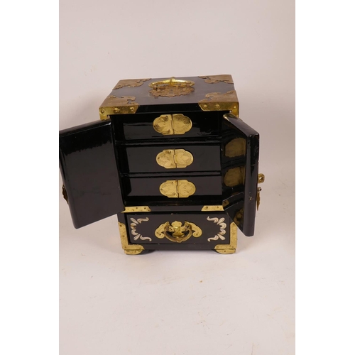 21 - A Chinese brass bound lacquered jewellery box with inlaid decoration, the two doors revealing three ... 