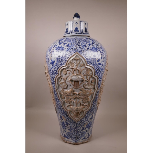 23 - A large Chinese blue and white pottery vase of octagonal form, the panels with raised decoration of ... 