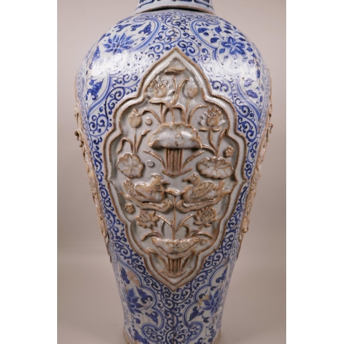 23 - A large Chinese blue and white pottery vase of octagonal form, the panels with raised decoration of ... 