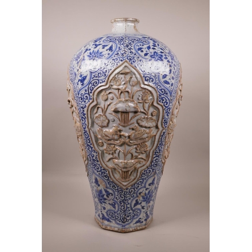 23 - A large Chinese blue and white pottery vase of octagonal form, the panels with raised decoration of ... 