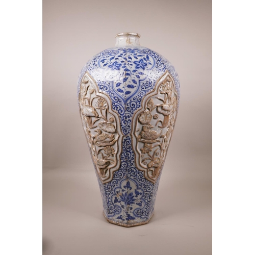 23 - A large Chinese blue and white pottery vase of octagonal form, the panels with raised decoration of ... 