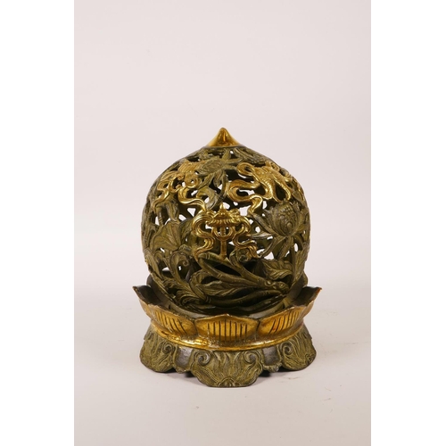 30 - A Chinese pierced bronze ball censer decorated with the eight Buddhist treasures, highlighted with g... 