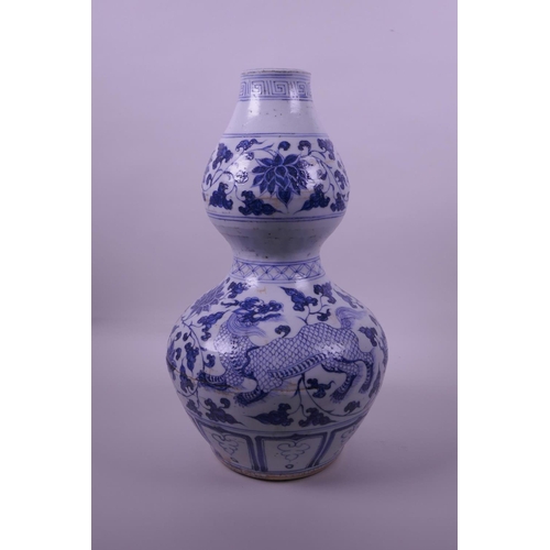 38 - A Chinese blue and white pottery double gourd vase decorated with lotus flowers and kylin, 13½