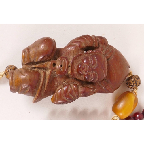 42 - A small Chinese carved cigarwood figurine of a boy carrying a large peach, 2¼