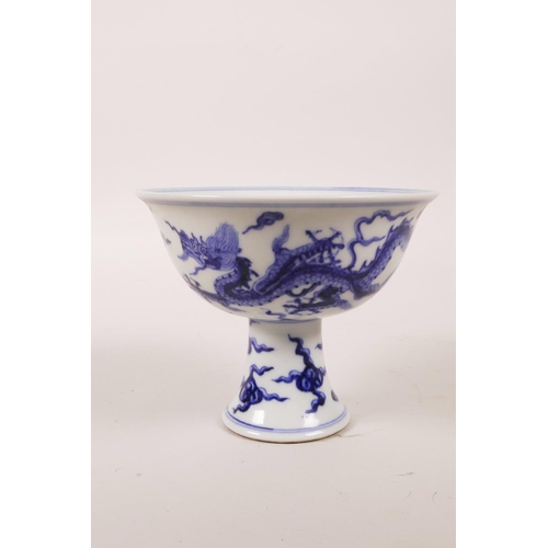 60 - A Chinese blue and white porcelain stem cup decorated with two dragons chasing the flaming pearl, 6 ... 