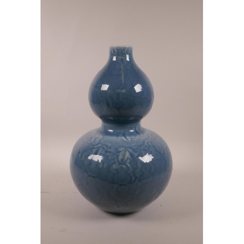 15 - A Chinese blue glazed double gourd vase with underglaze decoration of a fruiting gourd vine, seal ma... 