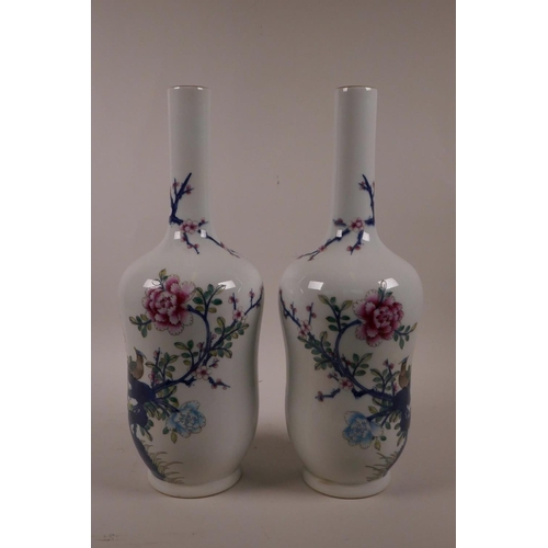 28 - A pair of Chinese polychrome porcelain vases with slender necks decorated with Asiatic birds amongst... 