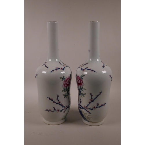 28 - A pair of Chinese polychrome porcelain vases with slender necks decorated with Asiatic birds amongst... 