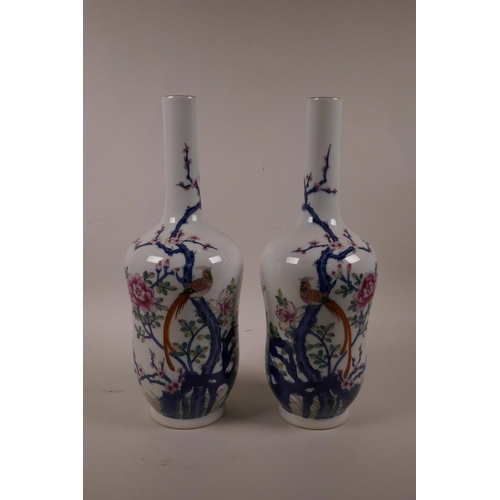 28 - A pair of Chinese polychrome porcelain vases with slender necks decorated with Asiatic birds amongst... 