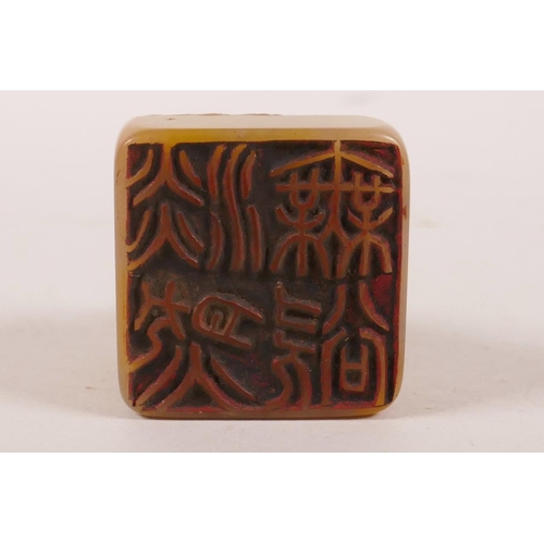 35 - A Chinese amber soapstone seal with a knop carved in the form of a horse, character inscription to s... 