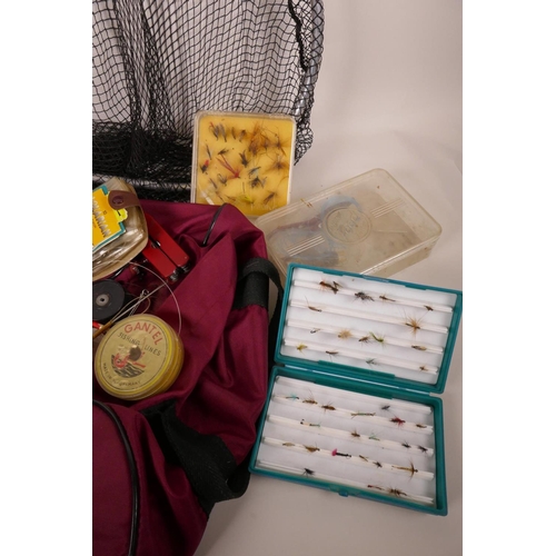 44 - A collection of fishing flies in three boxes and a tin, together with a landing net and a bog of mis... 