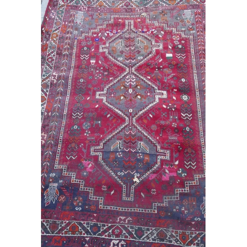 1115 - A Persian red ground carpet with geometric pattern, edges frayed, 71