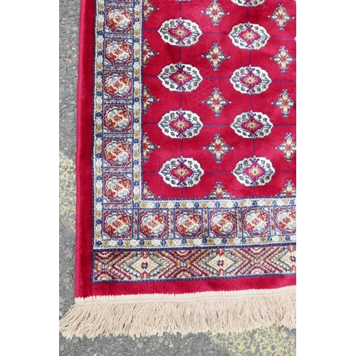 1134 - A pair of red ground Kashmir rugs with traditional Bokhara design, 26½